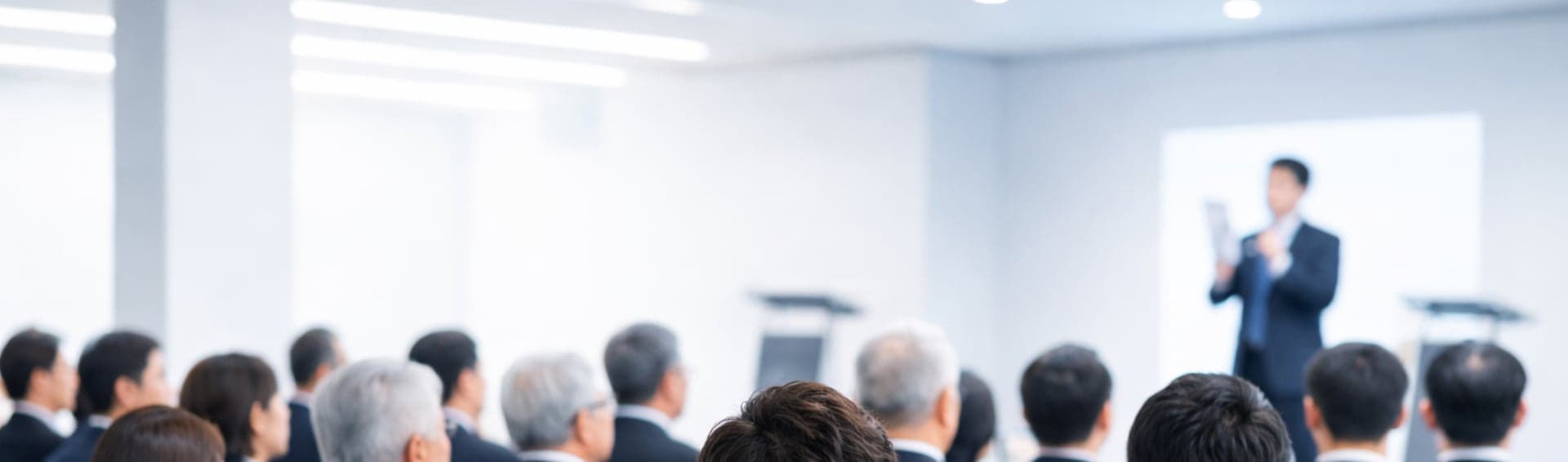 説明会の会場で登壇者の話を聞く参加者