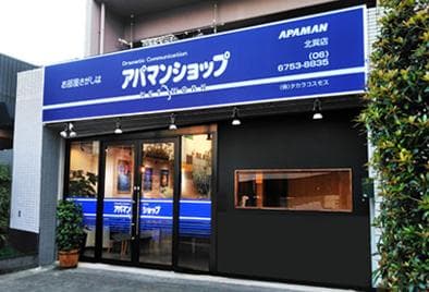 路面店の外観。青い看板と明るい店内が歩行者から見えるつくり