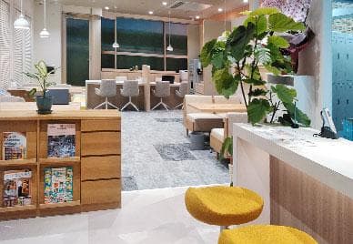 明るい待合スペースと資料棚を備えた店内